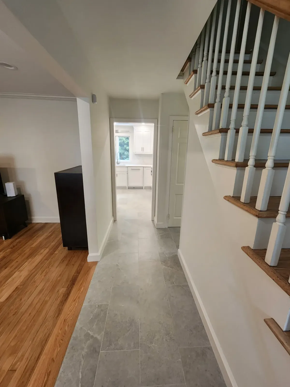 Hallway with new stone-look tile running from the living room through to a renovated kitchen in Scarsdale, NY