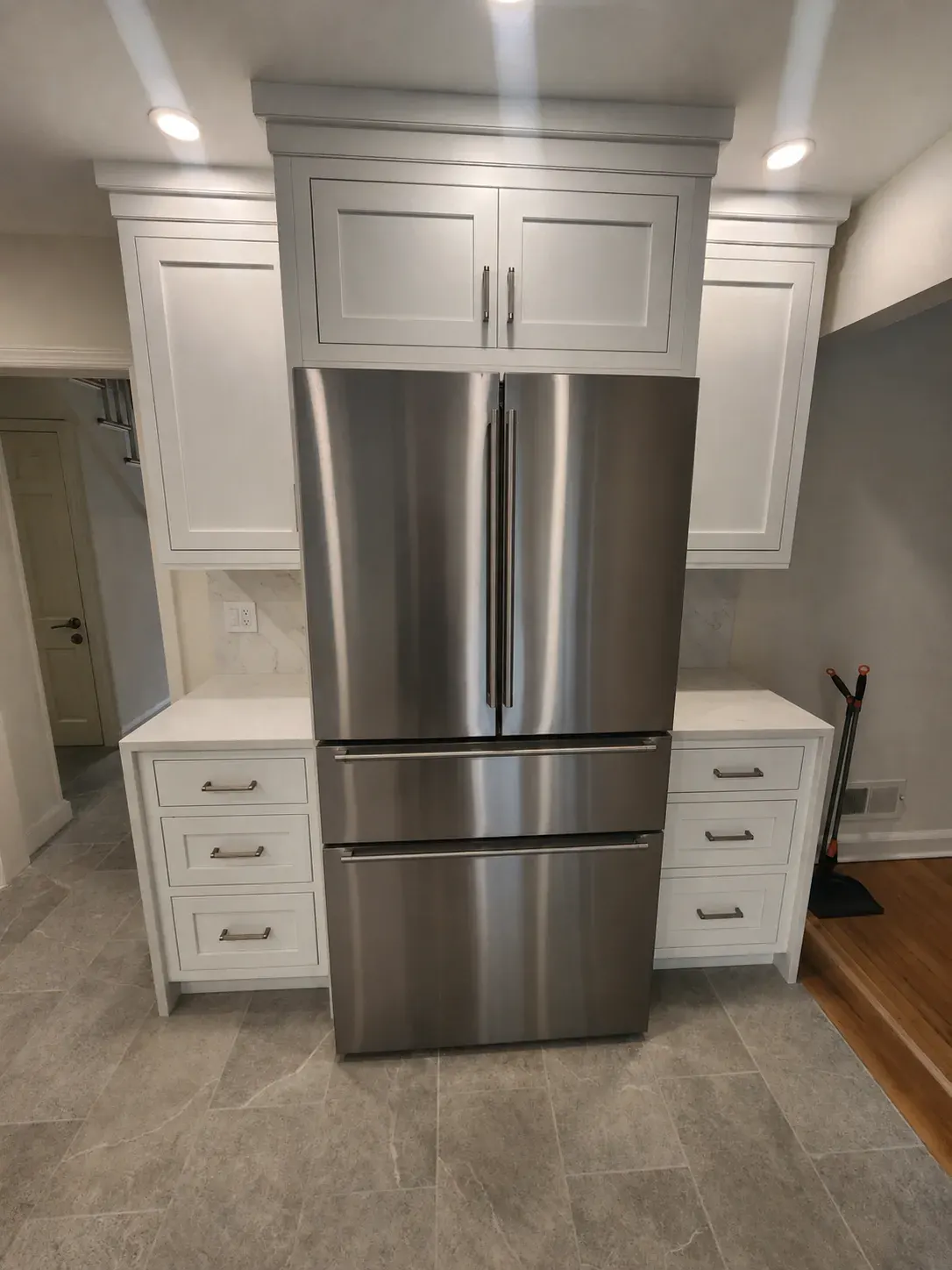 Refrigerator built into a custom cabinet surround with flanking drawer banks in a Scarsdale kitchen